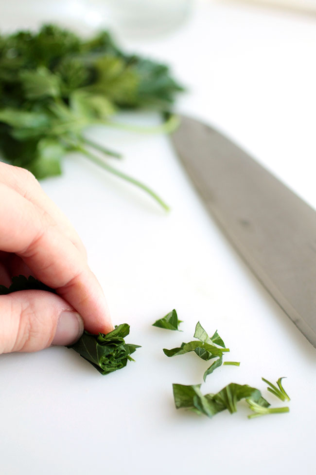 Rolling basil leaves into a bundle for easier chopping.