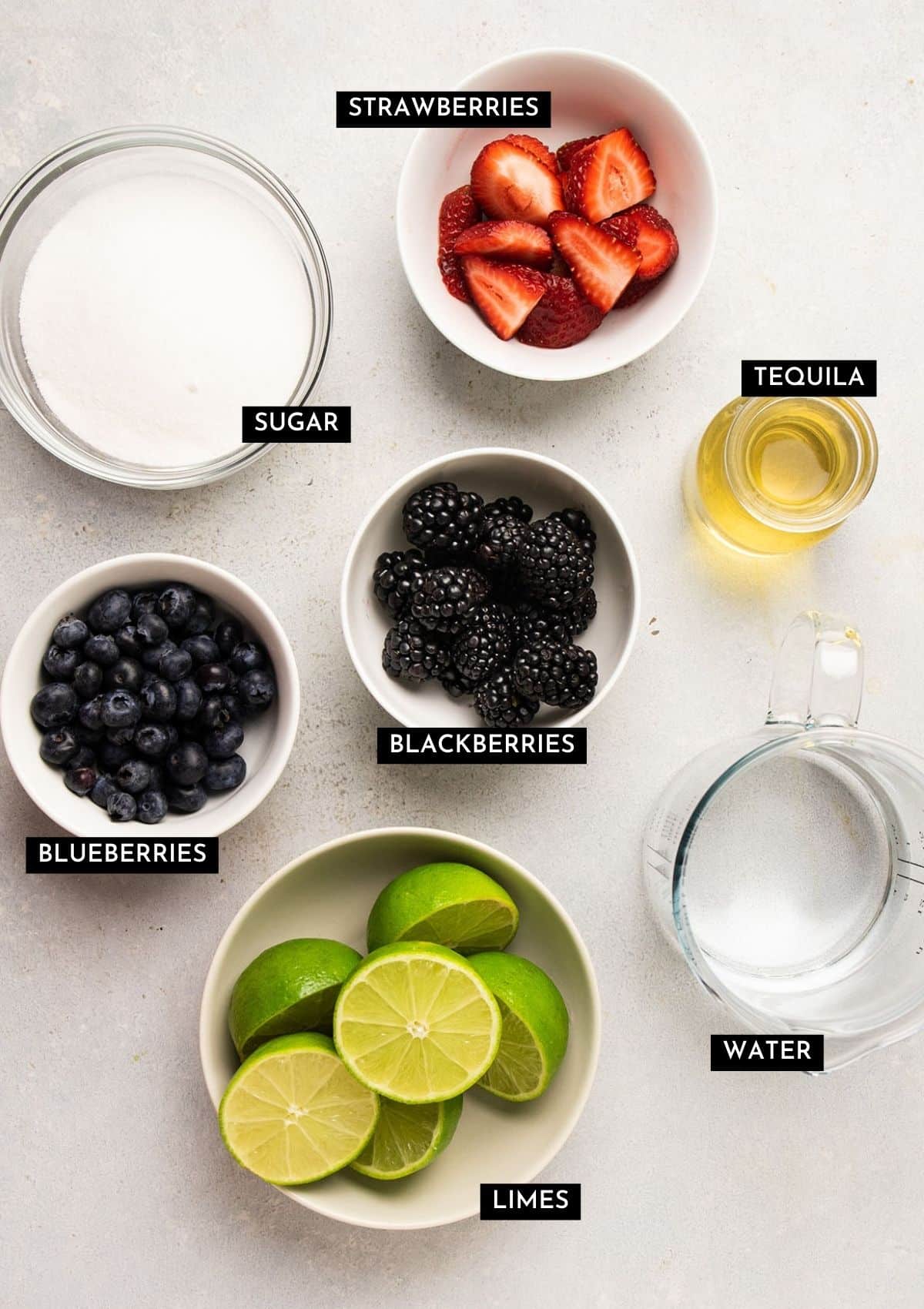 Berry margarita ingredients, measured into individual bowls.