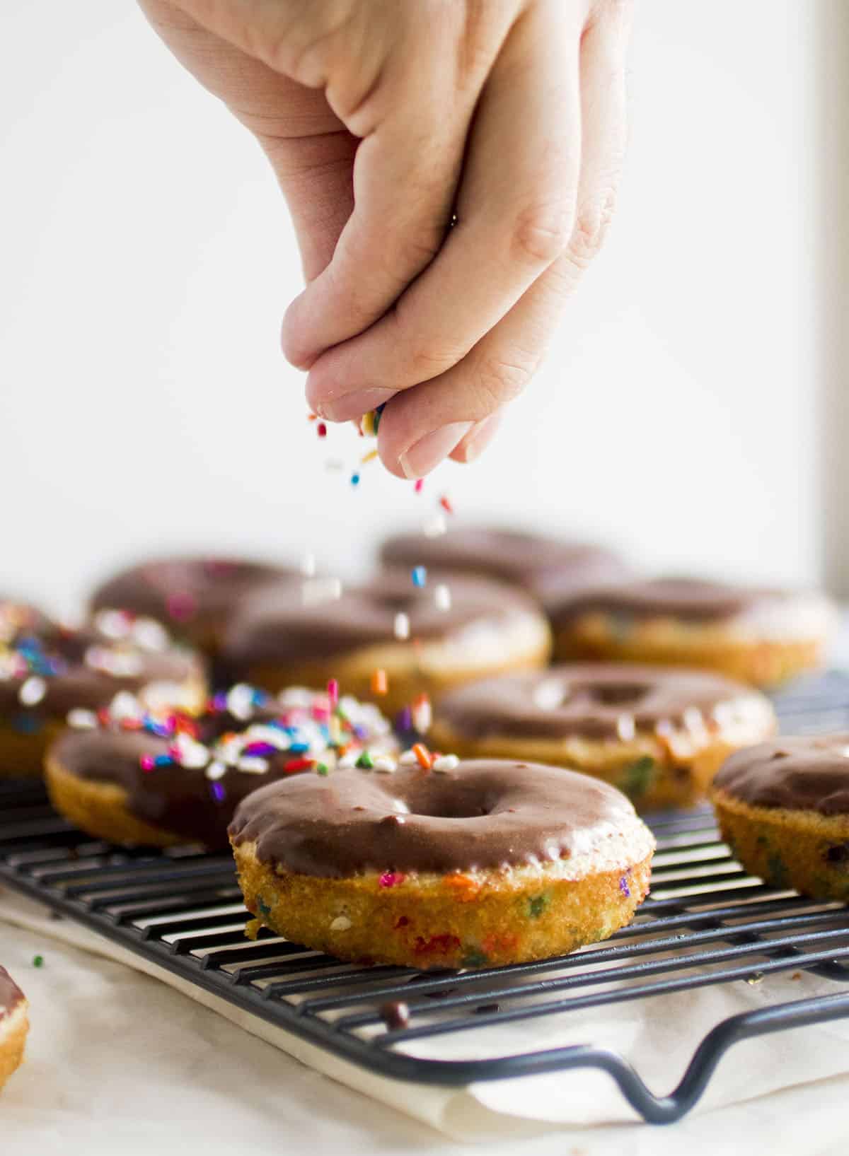 Adding sprinkles to donuts.