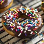 Baked donut with chocolate icing and rainbow sprinkles.