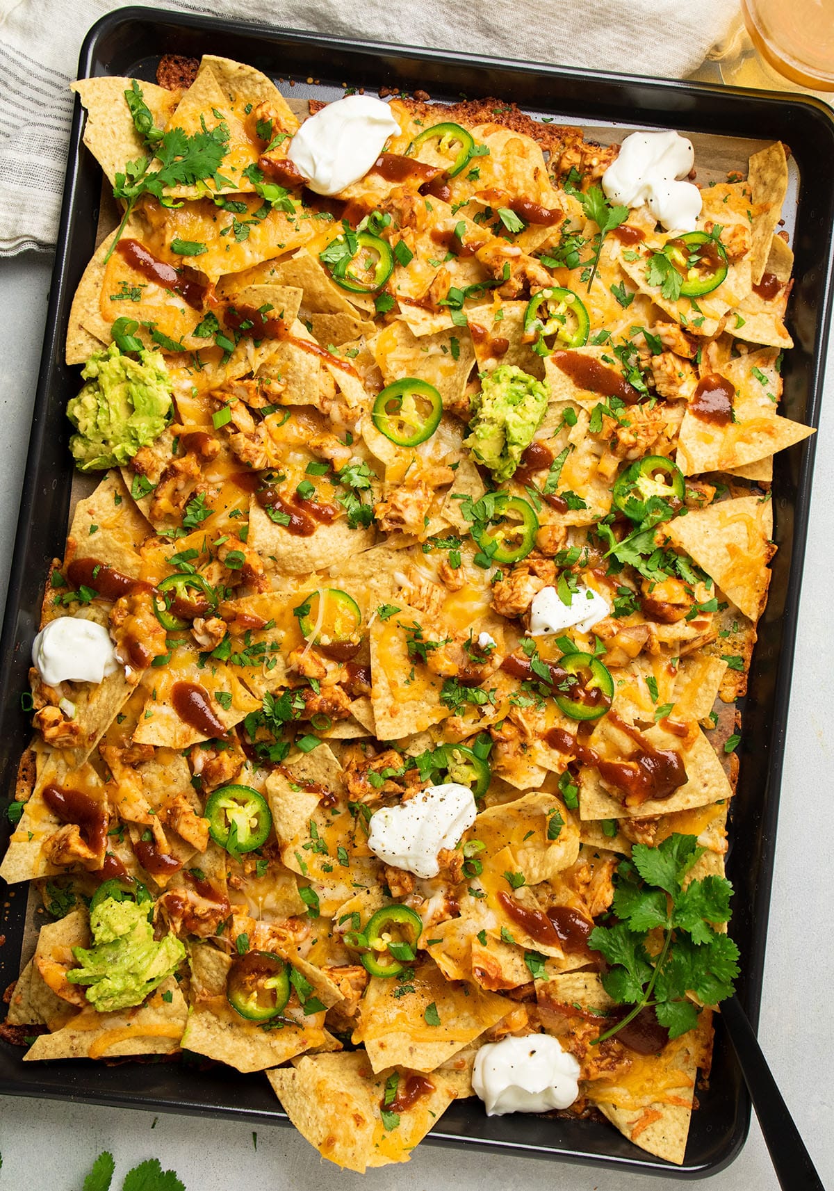Nachos with chicken, barbecue sauce, and jalapenos.