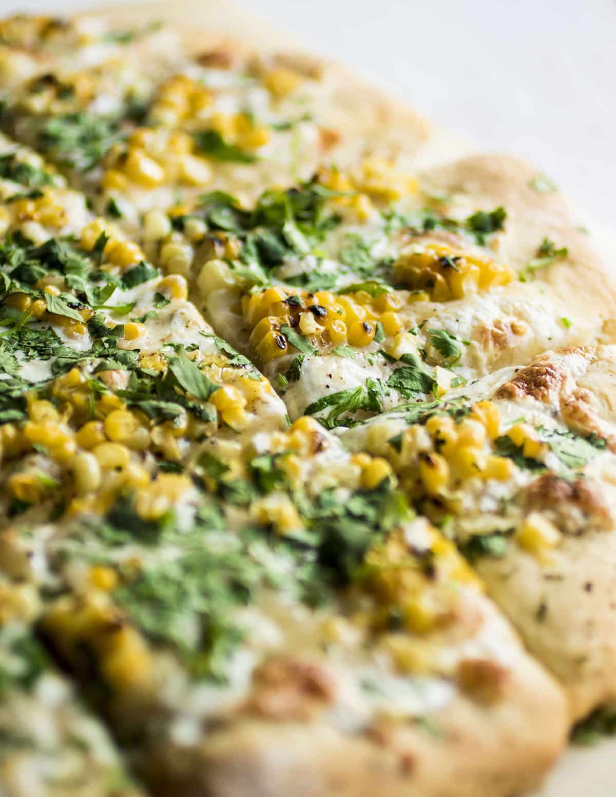 Corn pizza on a white table.