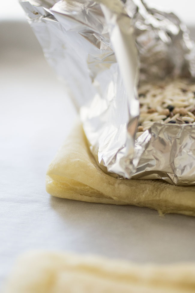 Puff pastry weighed down with rice-filled tin foil packet.