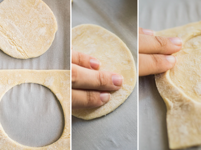 Hands pressing a piece of puff pastry into a circle.