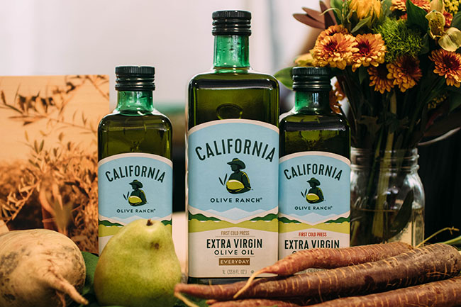 Three bottles of olive oil on a table.