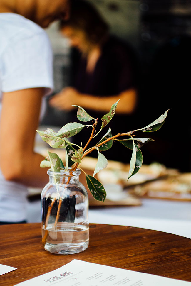 A sprig of greenery in a small glass bottle.