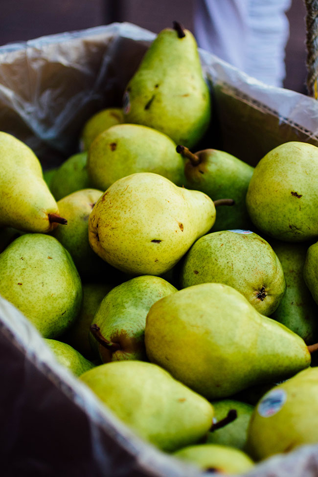Fresh pears in a large cardboard box.