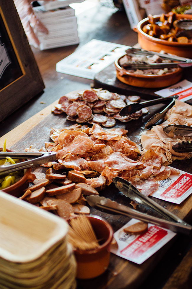 A large wooden cutting board with various charcuterie options.
