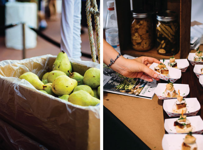 A box of fresh pears next to an appetizer table.