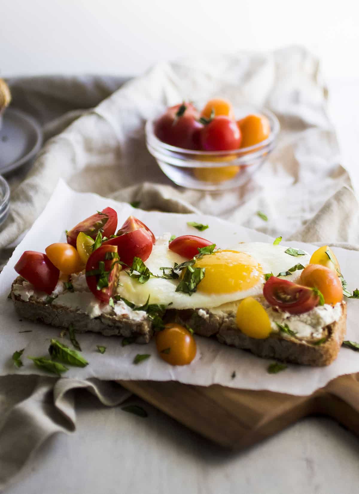 Toast topped with a sunny side up egg and fresh tomatoes.