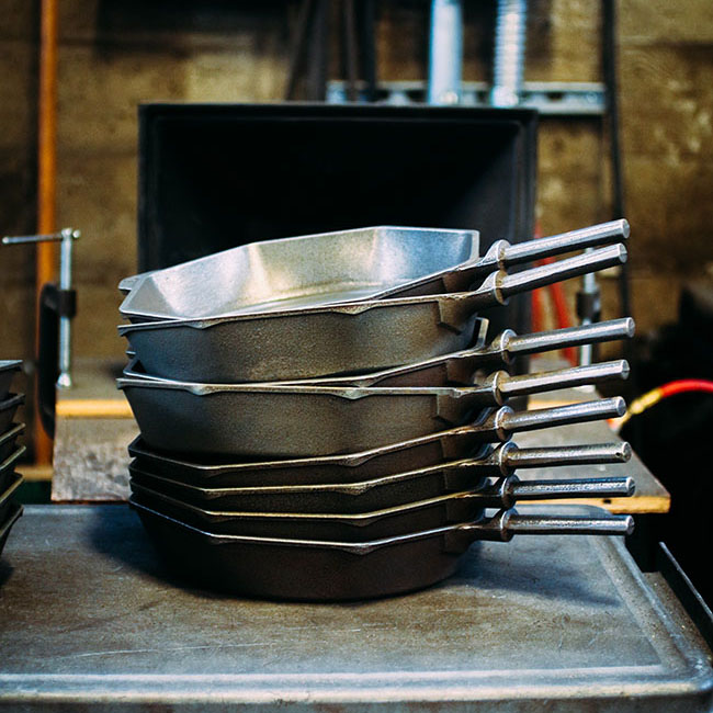 A stack of cast iron skillets in the Finex factory.