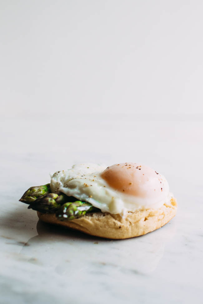 Poached egg and asparagus spears on an english muffin.