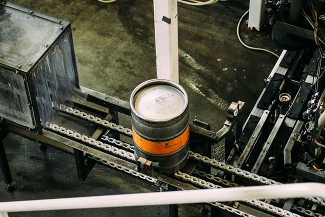 Looking down at a metal beer keg from the second floor.