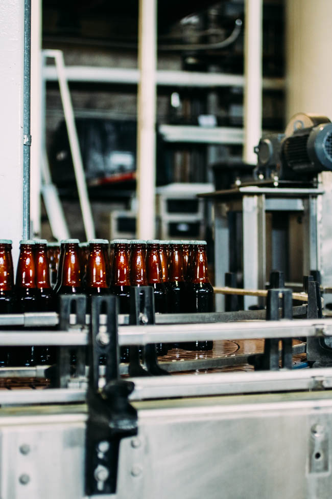 Beer bottles on a warehouse assembly line after being filled.