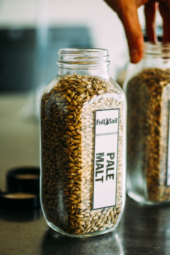 Glass container filled with hop pellets.