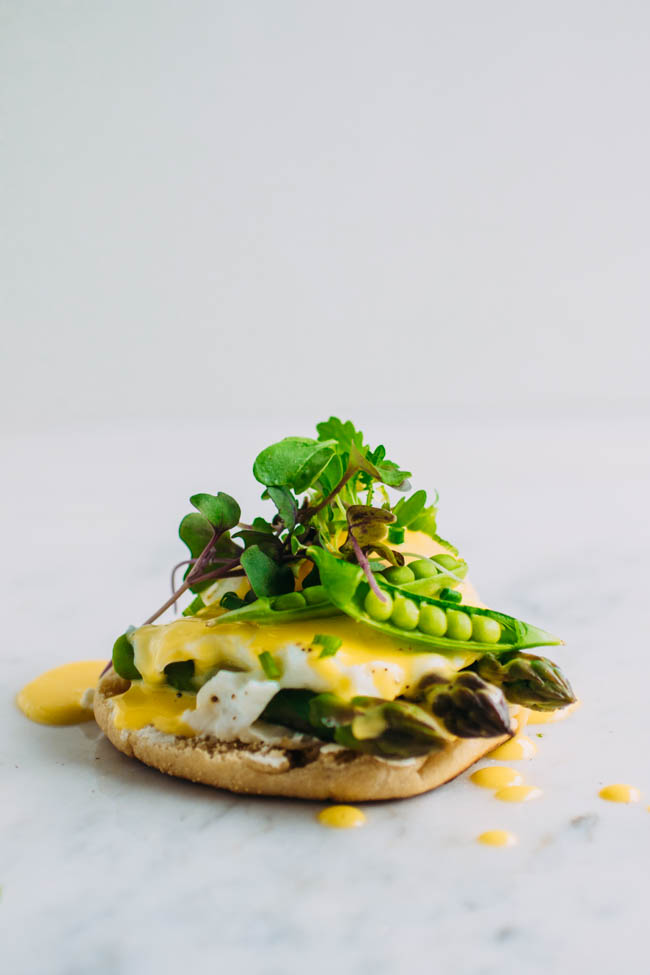 Toasted english muffin with asparagus and a poached egg, drizzled with hollandaise and topped with microgreens.