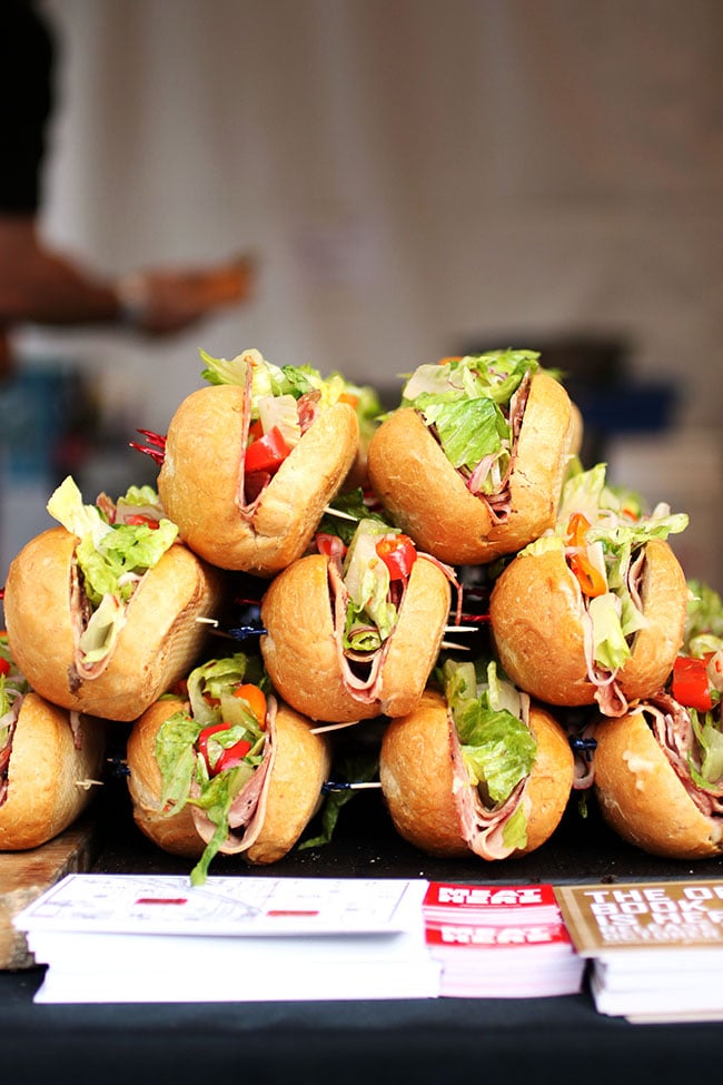 Several sub sandwiches stacked in a pyramid shape.