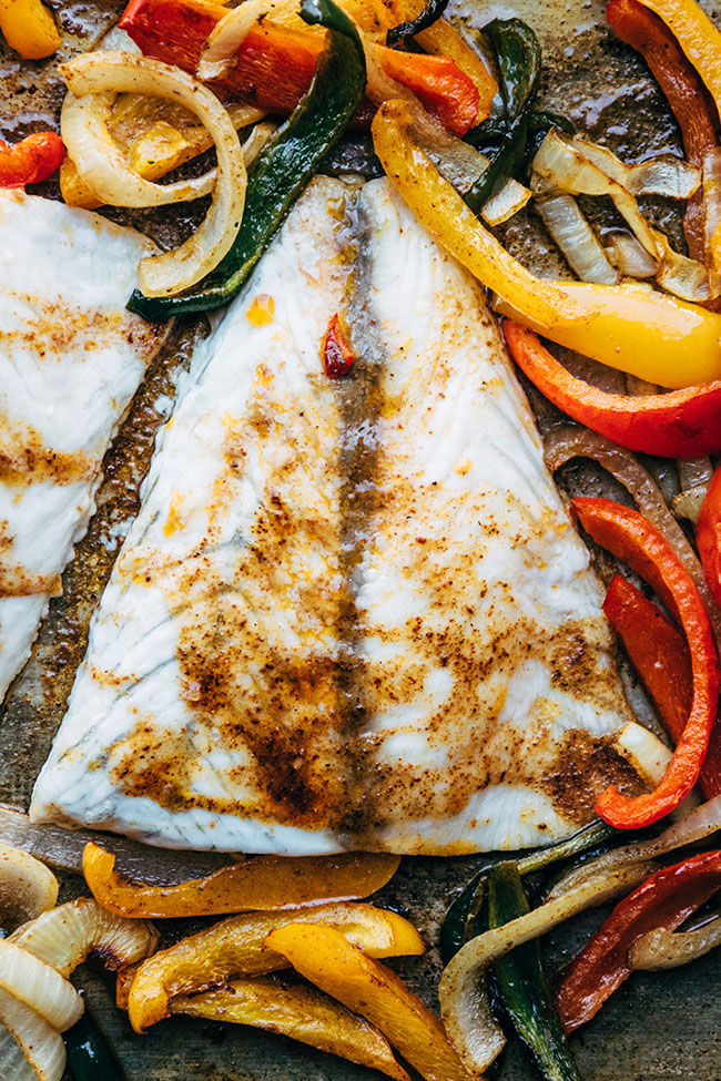 Close up of a baked barramundi fillet topped with spice rub.