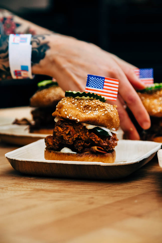 Pulled pork sliders topped with pickles and an American Flag toothpick.