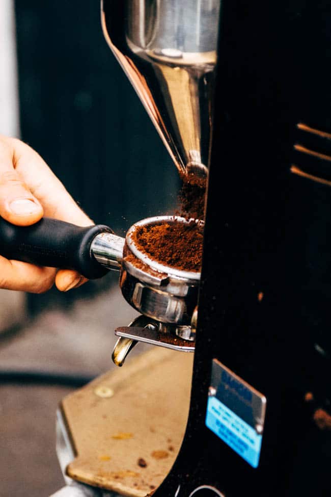 Hands pouring espresso into a coffee press.