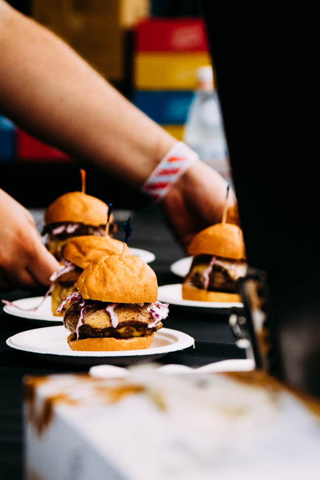 Three slider burgers on white appetizer plates.