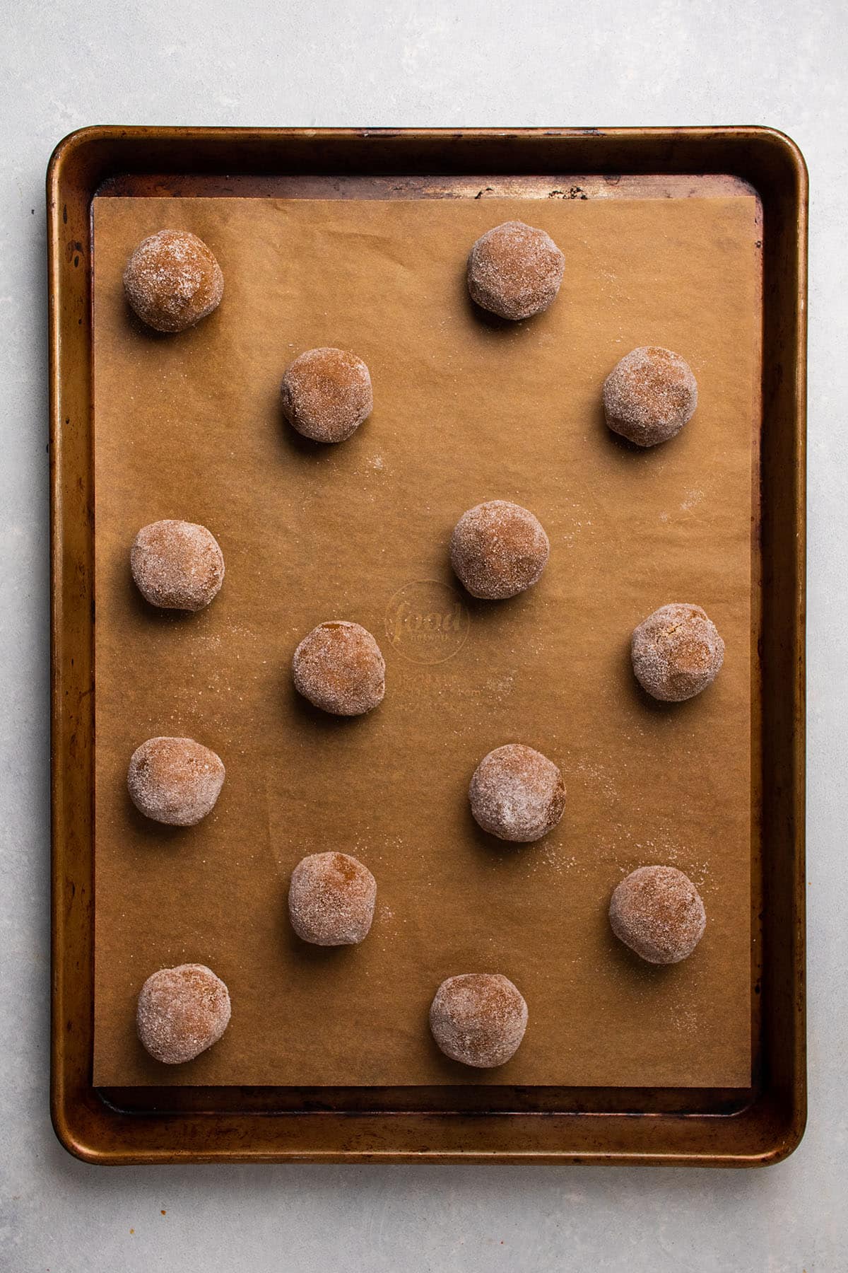 Gingersnap dough on a cookie sheet before baking.