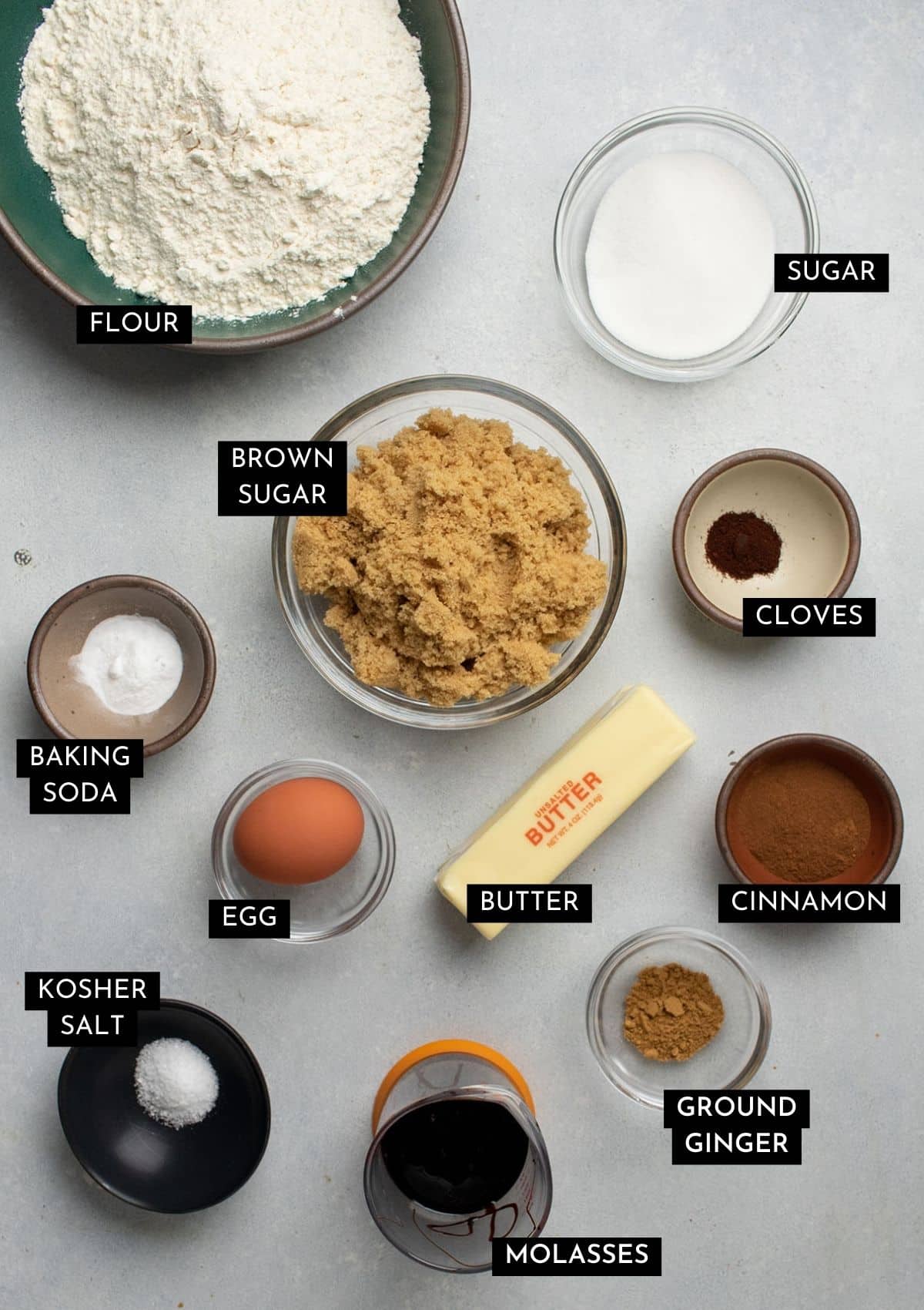 Gingersnap ingredients in individual bowls on a white table.