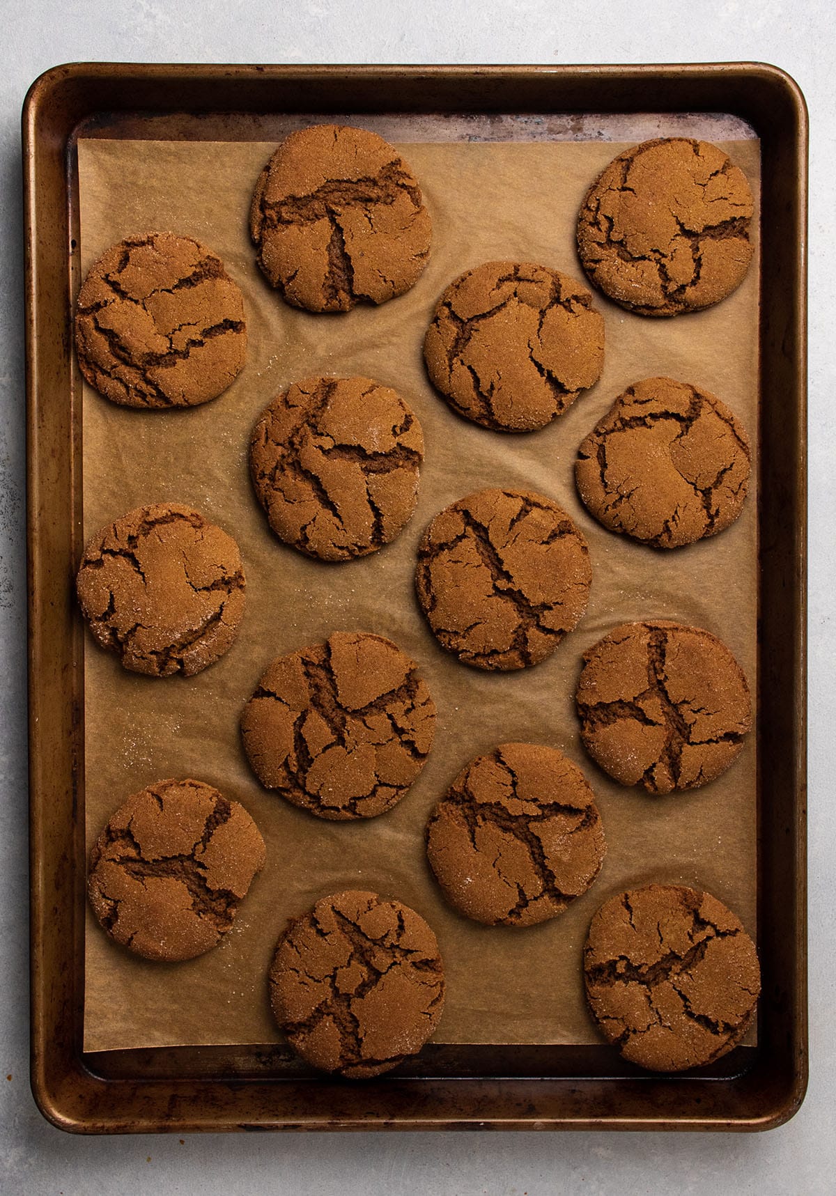 Cooked gingersnaps on a baking sheet lined with parchment paper.