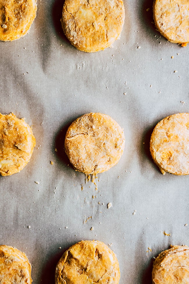 Raw biscuits on a parchment paper lined baking sheet.