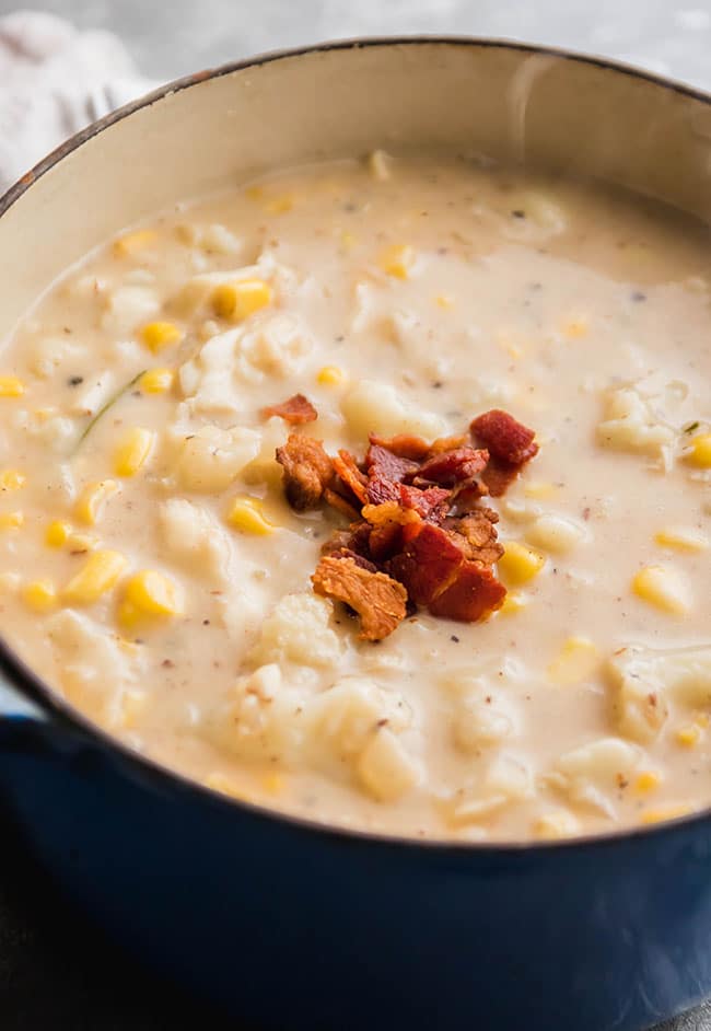 Fish chowder with corn and cauliflower in a large ceramic pot.