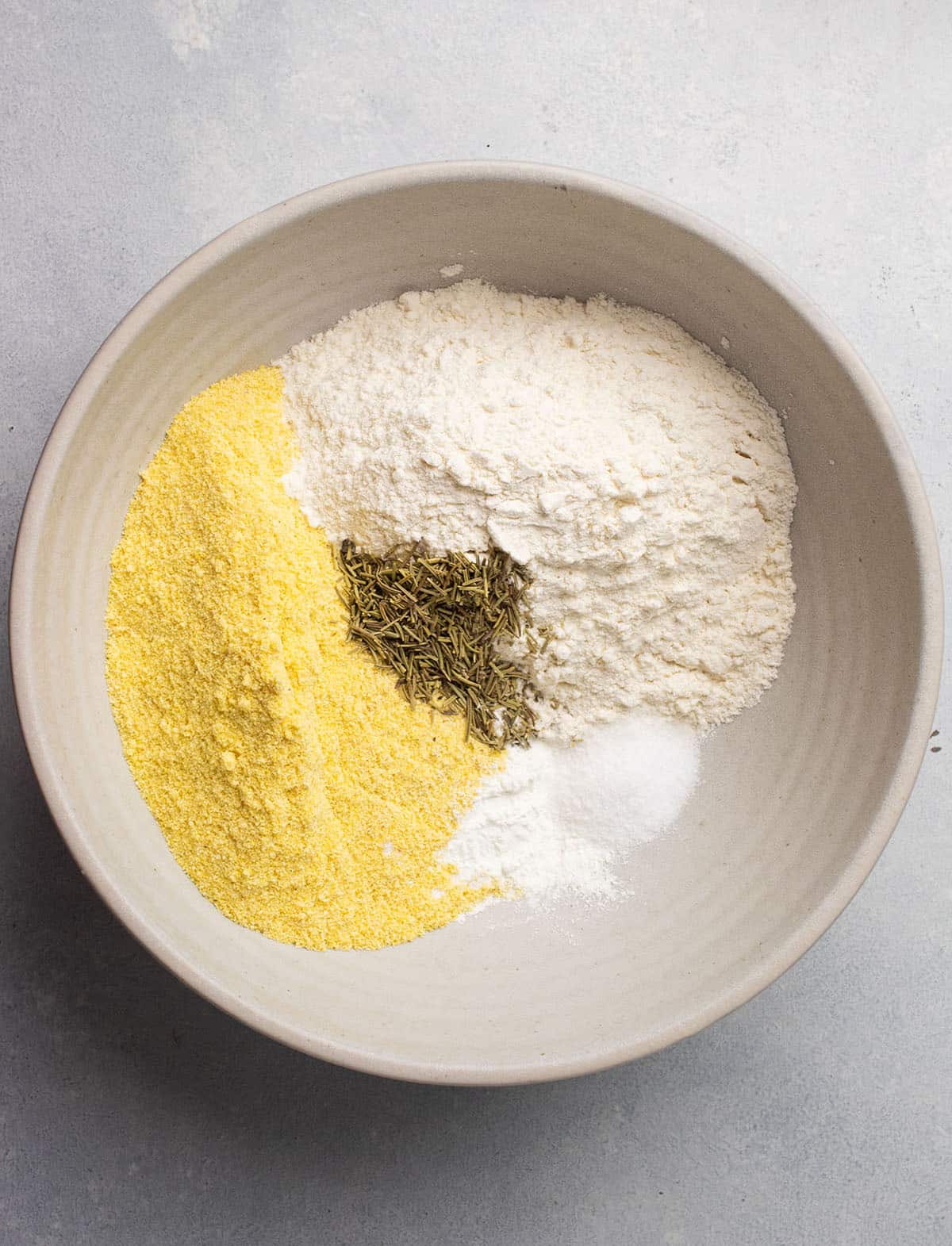 Flour, cornmeal, and rosemary in a large mixing bowl.