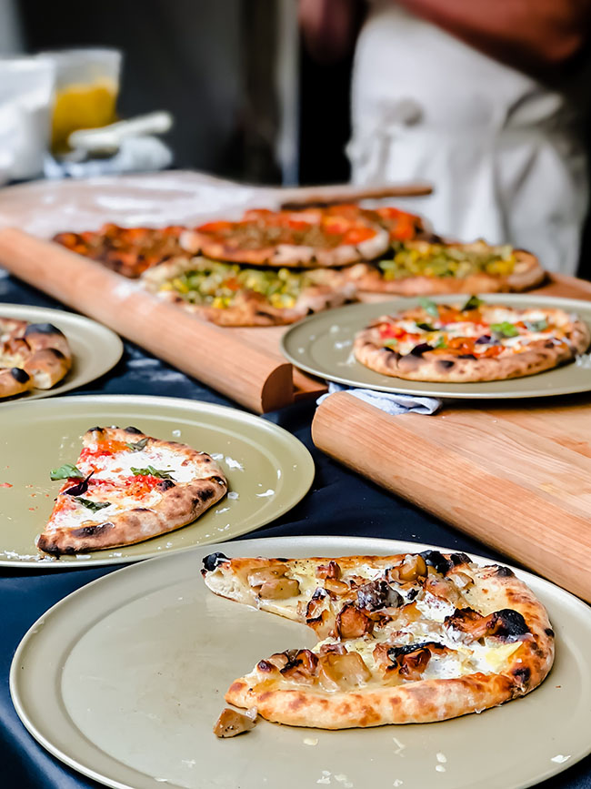 Wood fired pizza displayed on large cutting boards.