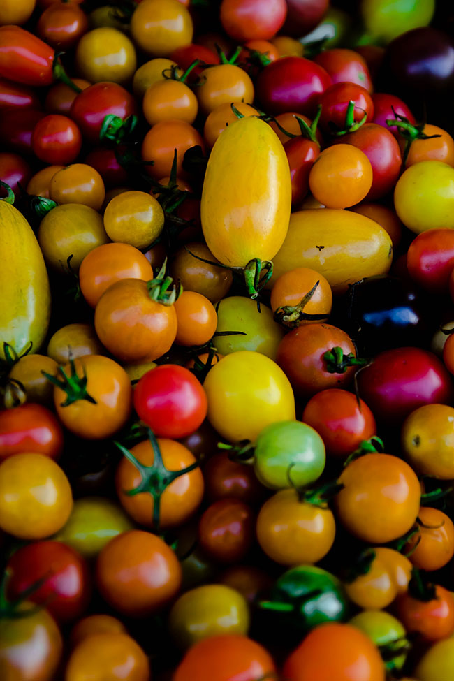 A pile of multi-colored cherry tomatoes.