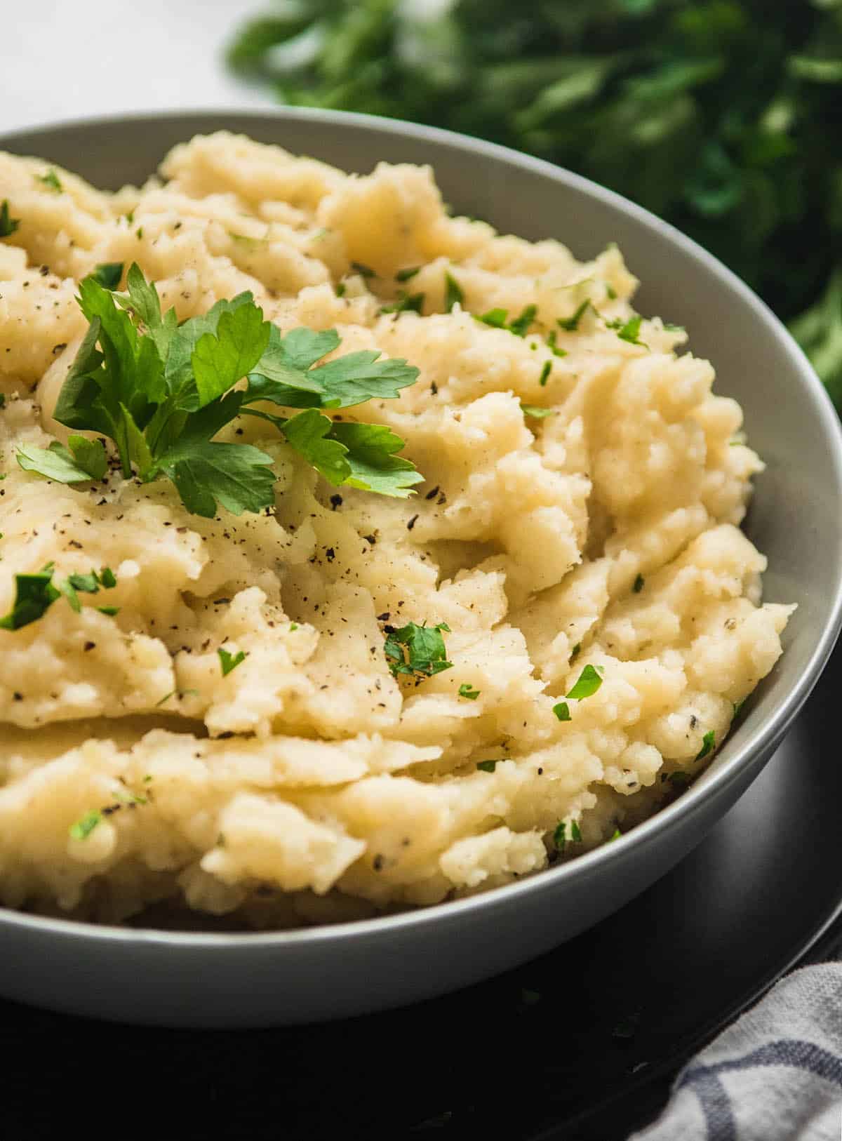 Mashed potatoes topped with parsley and black pepper.