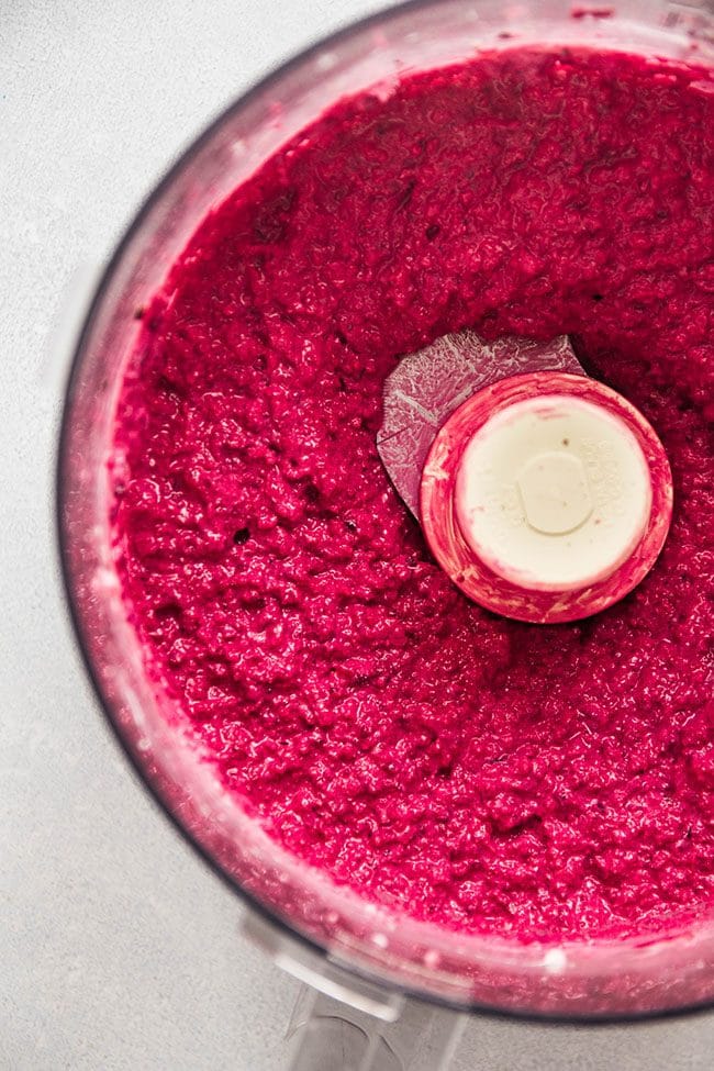 Close up of beet dip in the bowl of a food processor.