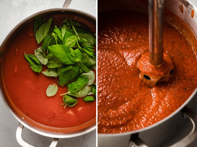 Immersion blender blending fresh basil into a pot of tomato soup.