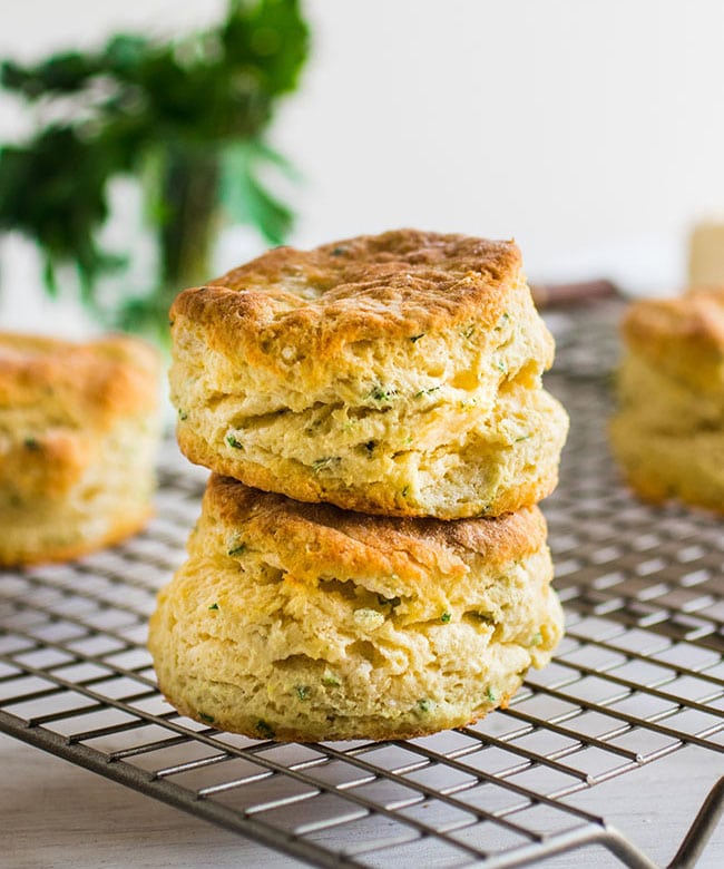 Two herbed biscuits stacked on top of each other on a wire cooling rack.