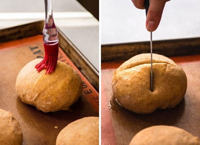 Using a small knife to score a bread bowl after brushing it with egg wash.