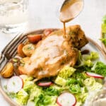 Maple dijon chicken on a plate with fresh salad and potatoes.