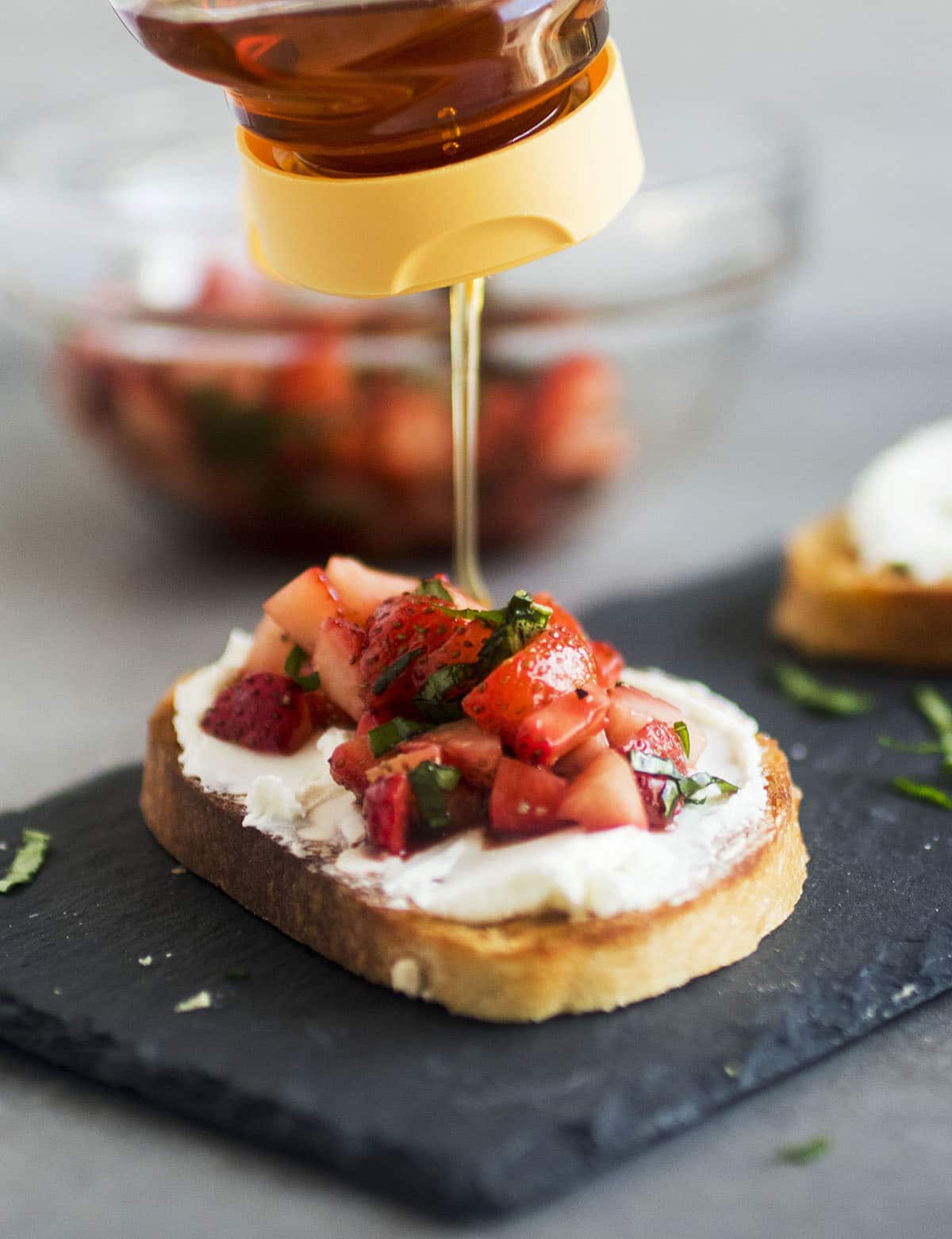 Drizzling honey over a piece of crostini.