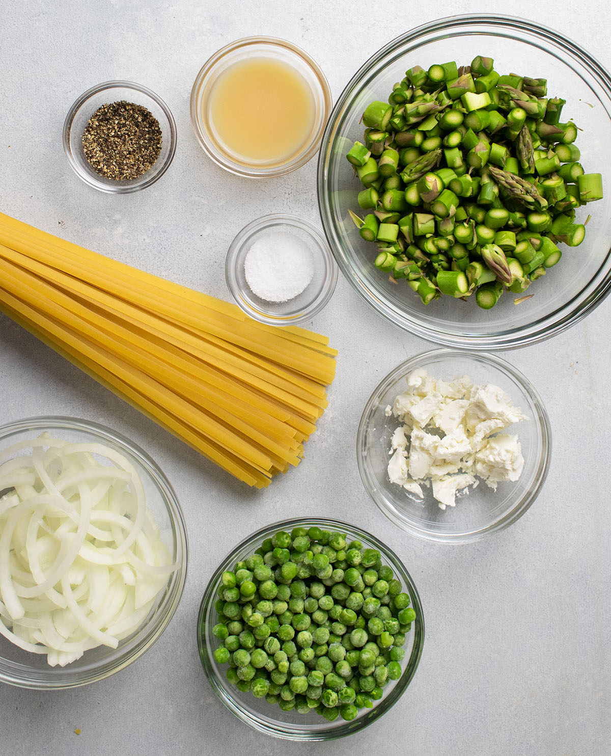 Spring pasta ingredients, organized into individual glass bowls.