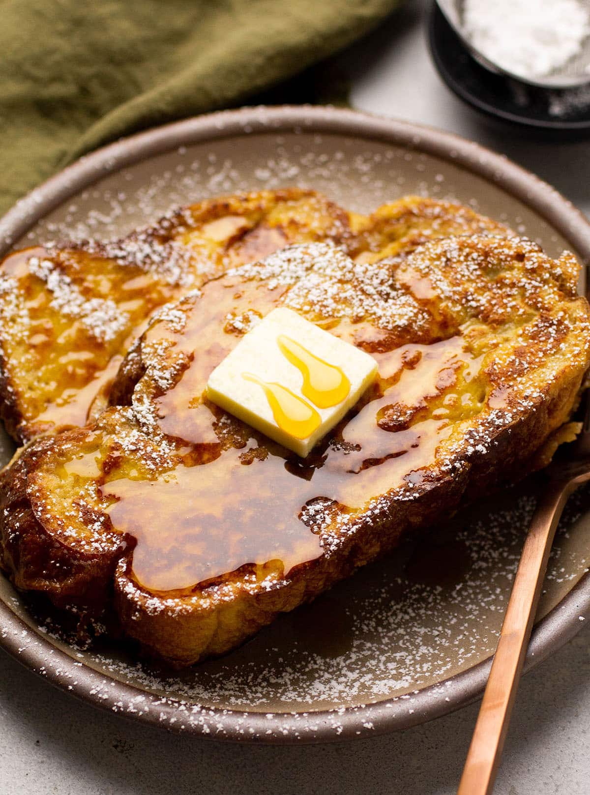 French toast topped with a pat of butter and maple syrup.