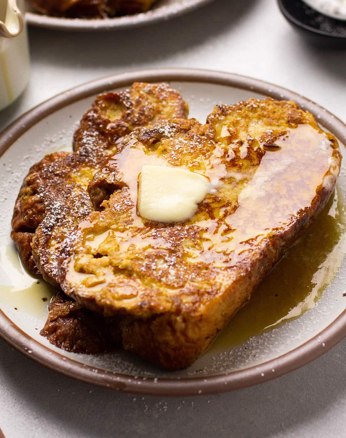 Two pieces of french toast on a grey plate.