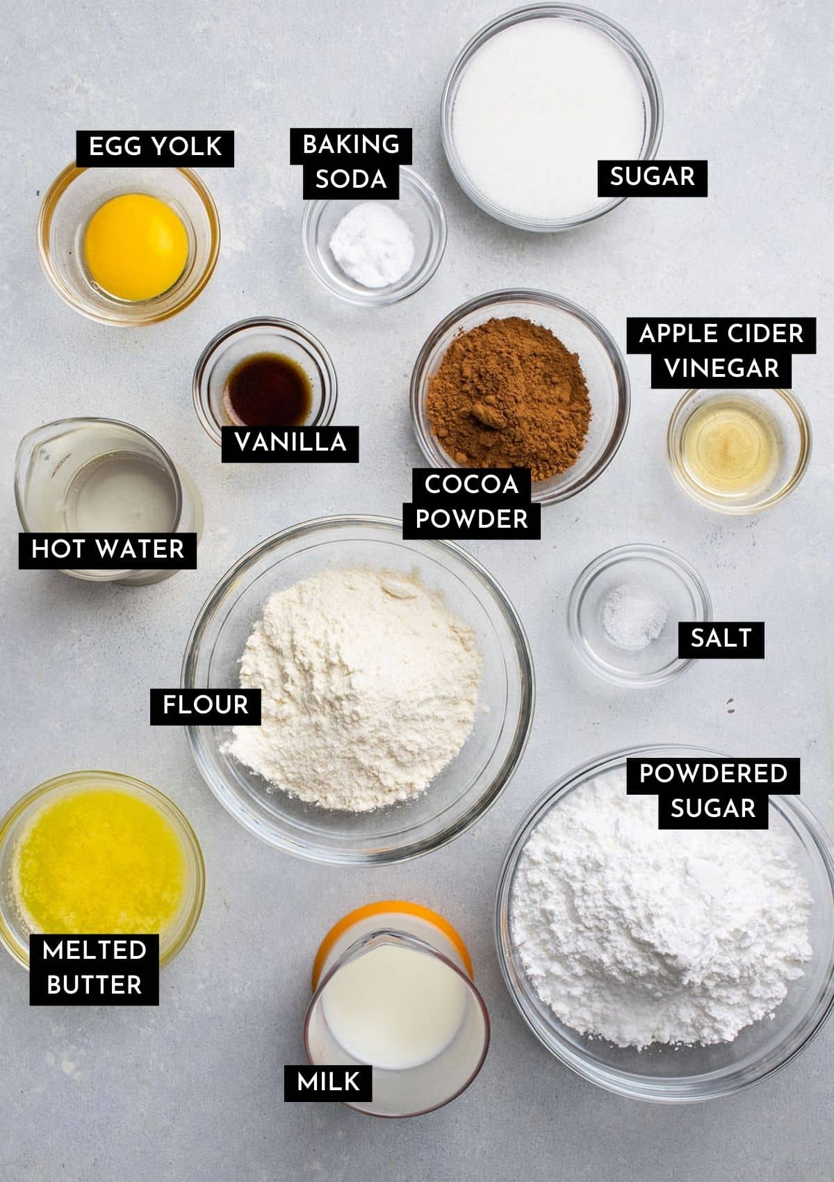 Chocolate cupcake ingredients, organized into individual bowls on a white table.