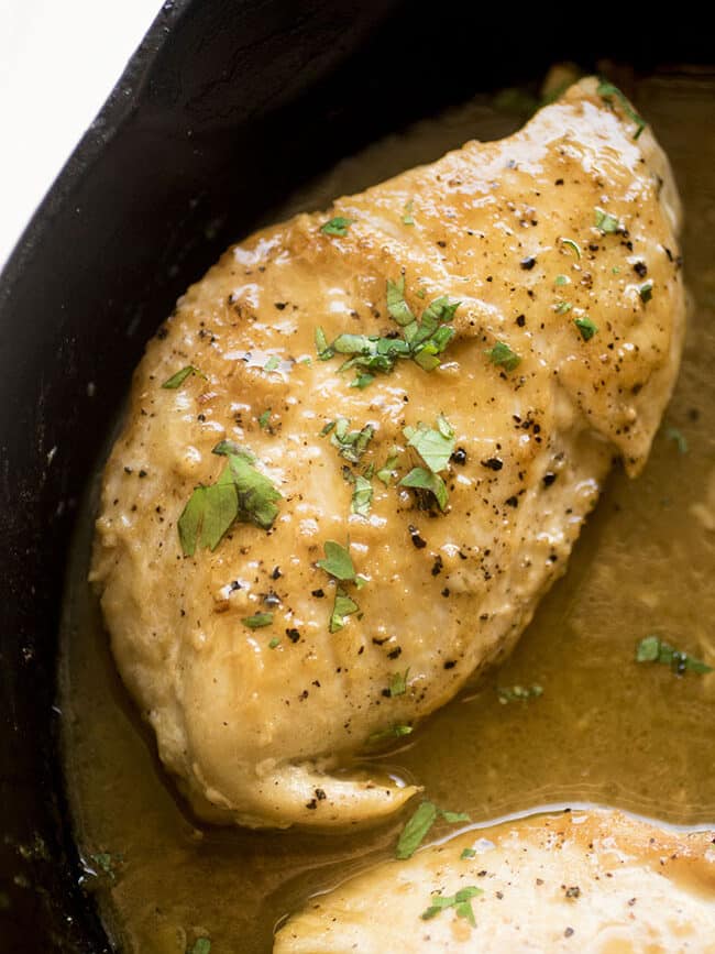 Baked chicken breast in a cast iron skillet with mustard sauce.