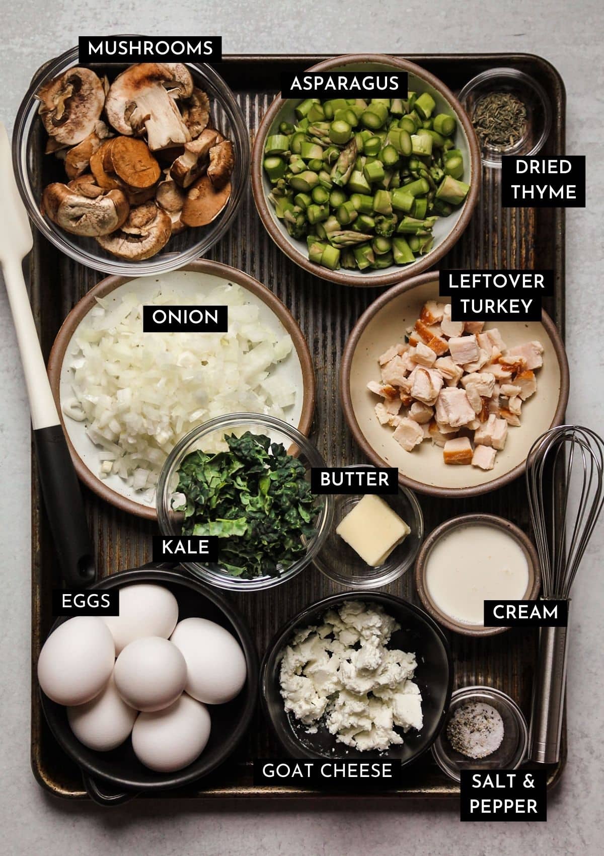 Turkey frittata ingredients, organized into individual bowls on a large sheet pan.