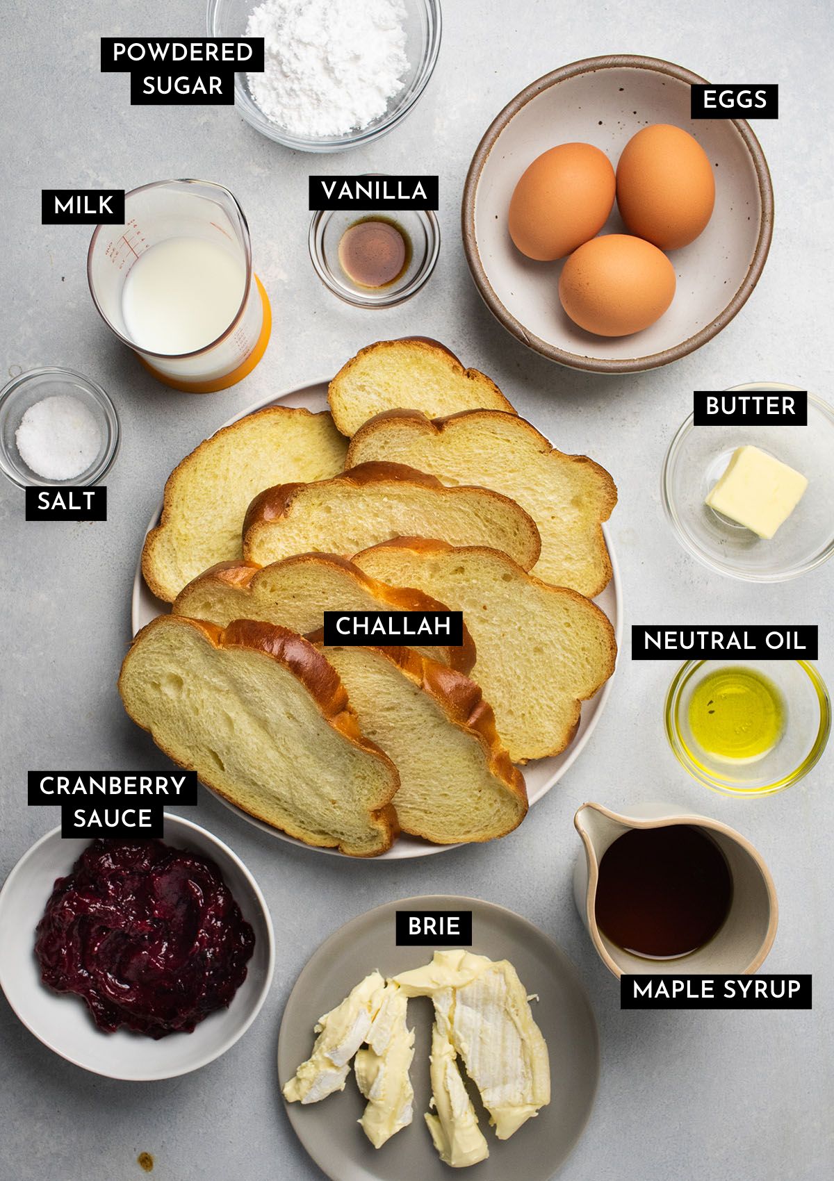 French toast ingredients, organized into individual bowls on a white table.