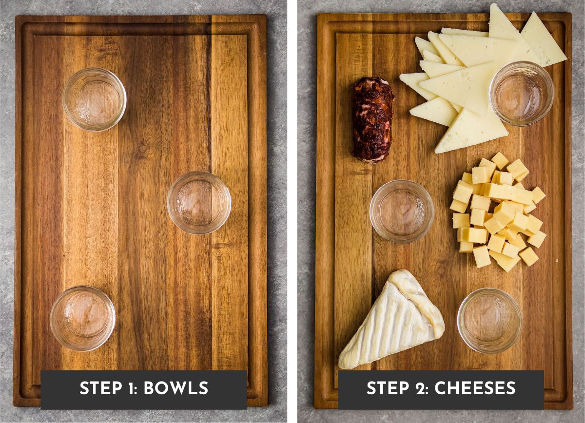 Wooden cutting board with three small bowls and a variety of cheeses.
