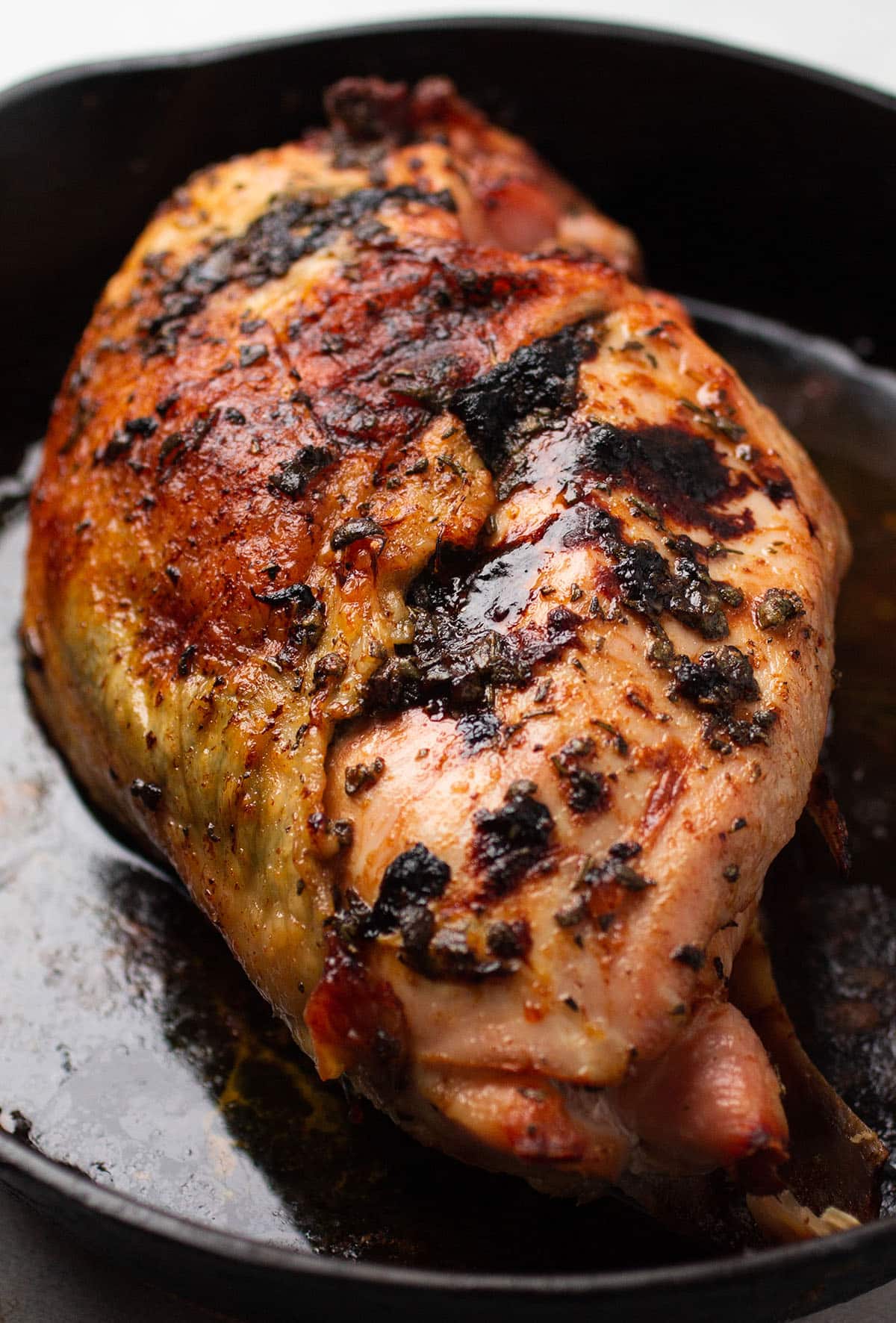 Roast turkey breast with crispy skin in a cast iron skillet.