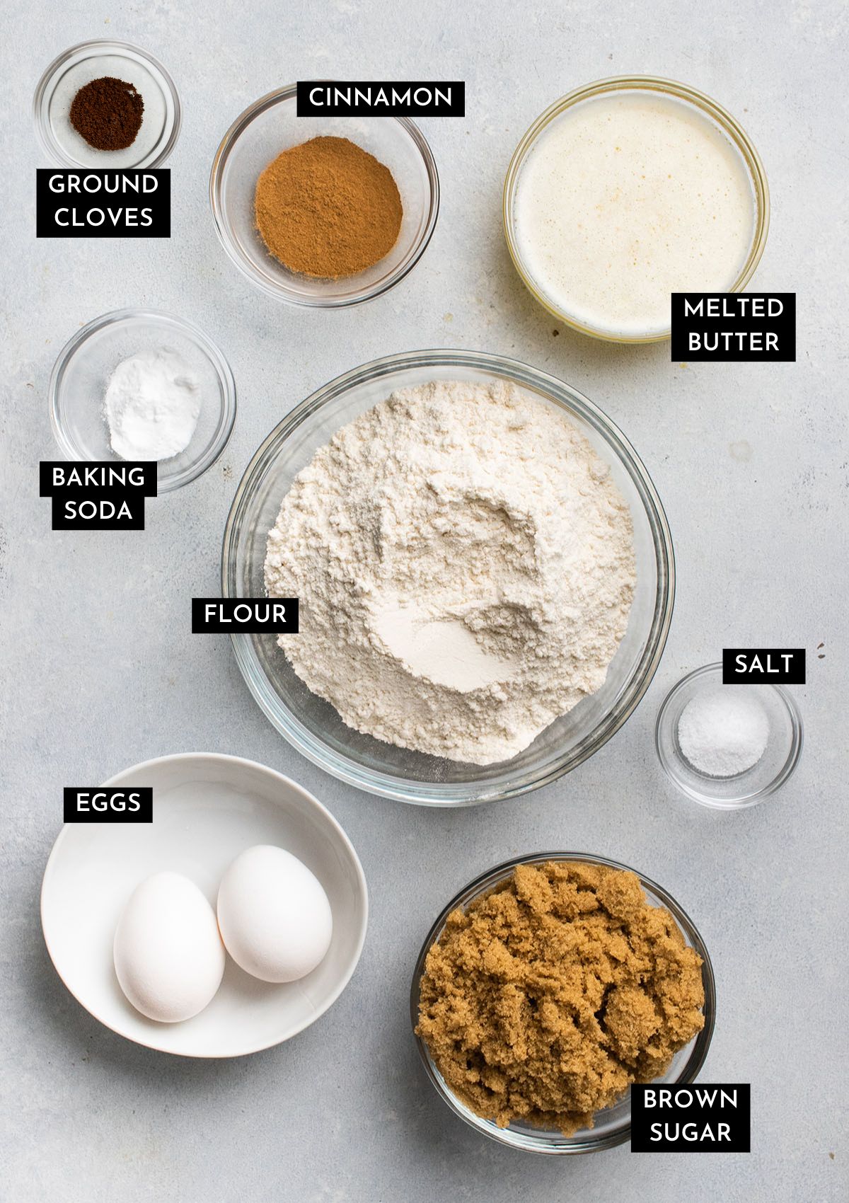 Cookie ingredients, organized into individual bowls on a white table.